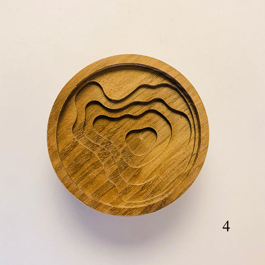 Wooden coaster with wavy line design.