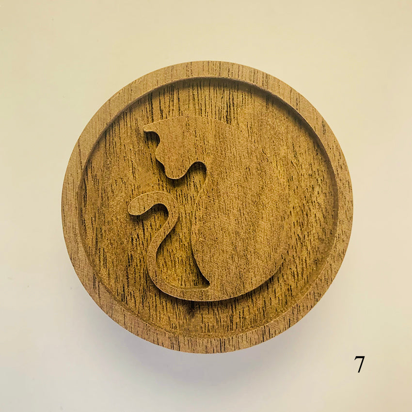 Wooden circular object with a cut-out design .