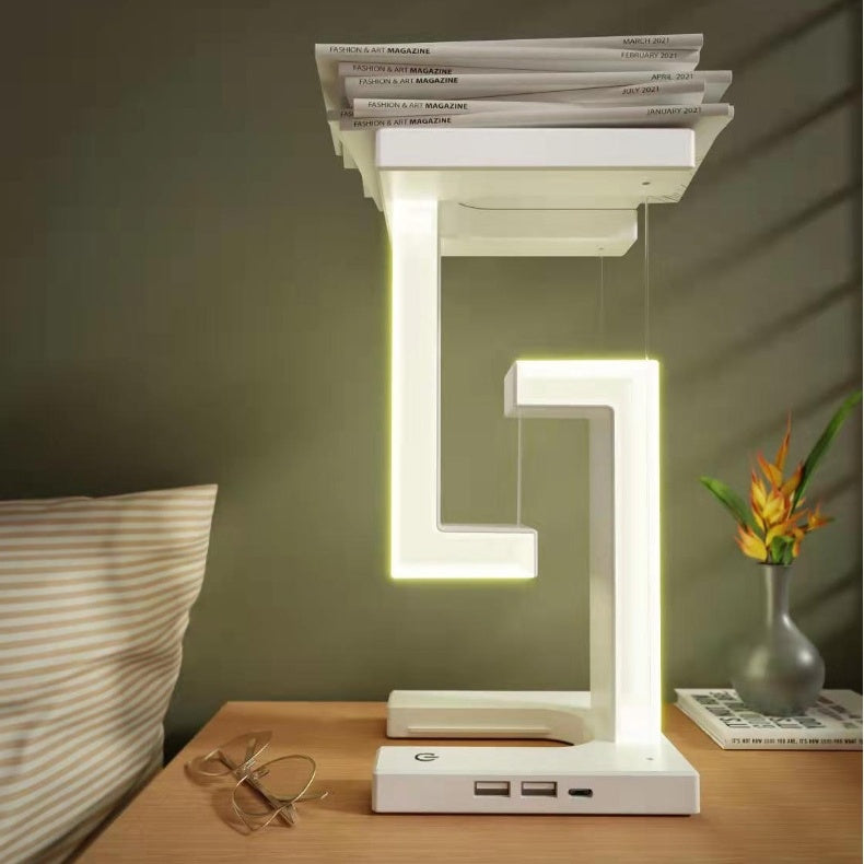 Modern LED desk lamp on a wooden surface with books and a plant in the background