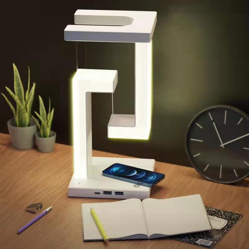 Modern desk lamp on a wooden surface with a phone, notebook, and clock in the background.